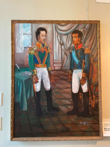 This painting was completed by contemporary artist Jean Yves Hector during his residency at the Haitian American Museum of Chicago (HAMOC). The painting is part of a wall of portraits depicting Haitian leaders, and depicts the meeting of Simón Bolívar and Alexandre Pétion. Originally from Port-au-Prince, Hector now resides in Chicago, where they continue to make artwork and actively engage with HAMOC. More information on Hector’s work is available at https://jeanyveshector.wixsite.com/jeanyves.